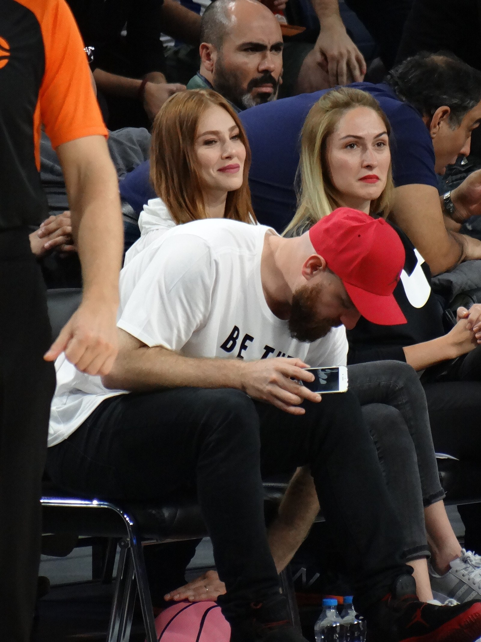Elçin Sangu sitting in the audience at a basketball game