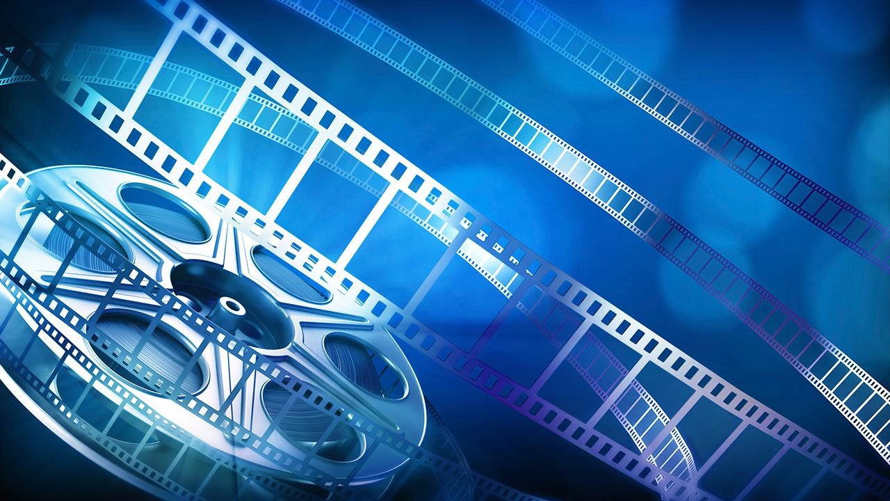 Film reel and strips of film on a blue background, illustrating cinema releases