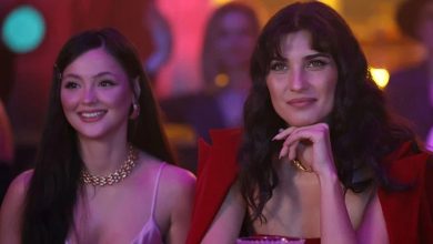Tuba Büyüküstün and another woman smiling in a dimly lit setting, possibly a scene from the film 'Sultana'.