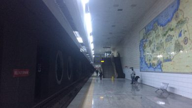 Metro platform at Milli Kütüphane station with a tiled map mural of Türkiye on the wall and a few passengers walking.